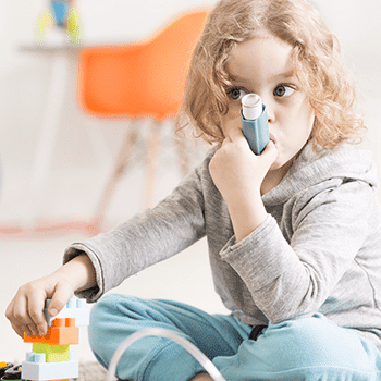 young child using inhaler